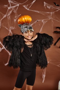 close up smiling preteen girl with pumpkin on her head and hands under chin, Halloween clipart