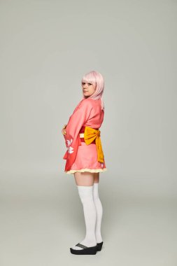Sarı peruklu, pembe kimonolu, gri kostümlü, genç anime tarzı kadın.
