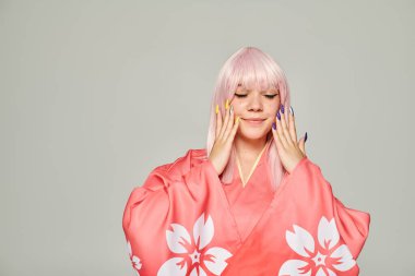 Çiçek desenli pembe kimonolu anime tarzı kadın ve gri arka planda renkli manikürlü eller.