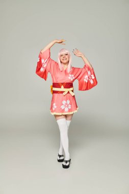 Renkli kimono ve beyaz diz çoraplı, elleri gri olan sarışın kadın kostümü.