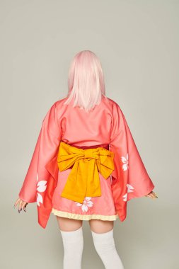Sarı peruklu, kısa pembe kimonolu, sarı kurdeleli, gri renkli, anime tarzı bir kadın.