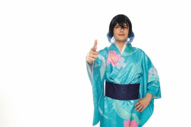 young creative man in blue kimono and wig pointing with finger at camera on white, cosplay culture clipart