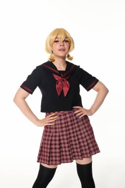 confident woman in yellow blonde wig and school uniform with hands on hips on white, cosplay concept clipart