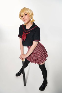Beyazlar içindeki kameraya bakan, modaya uygun okul üniformalı, uzun boylu bir anime kadın.
