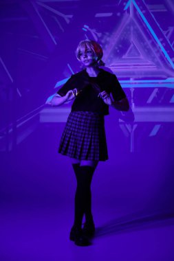 anime woman in blonde wig and school uniform in blue neon light on abstract backdrop, full length clipart