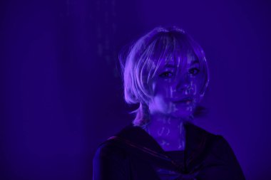 Sarı peruklu, hiyeroglifli, mavi neon ışıklı büyüleyici kadın Cosplayer portresi.