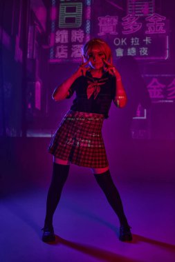 Okul üniformalı anime modeli mor neon arka planda hiyerogliflerle zafer işaretleri gösteriyor.