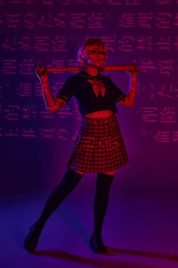 Okul üniformalı genç anime kadın elinde beyzbol sopasıyla neon mor zemin üzerinde hiyeroglifler var.