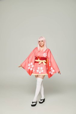 Sarı peruklu ve pembe kimonolu genç anime kadın. Gri, Japon alt kültürü üzerine.
