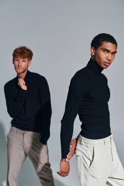 vertical shot of two multicultural men in black elegant turtlenecks looking at camera, fashion clipart