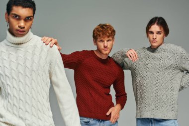 good looking diverse men in sweaters with hands on each others shoulders looking at camera, fashion clipart