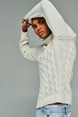 handsome young african american man in stylish sweater posing with raised arms, fashion concept clipart