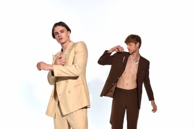 handsome young man in beige suit posing with other male model in unbuttoned suit, men power clipart