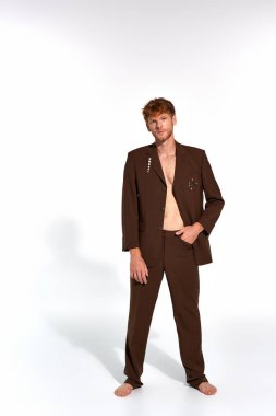 Kahverengi şık takım elbiseli şık bir adam. Aksesuarları kameraya bakıyor. Moda.