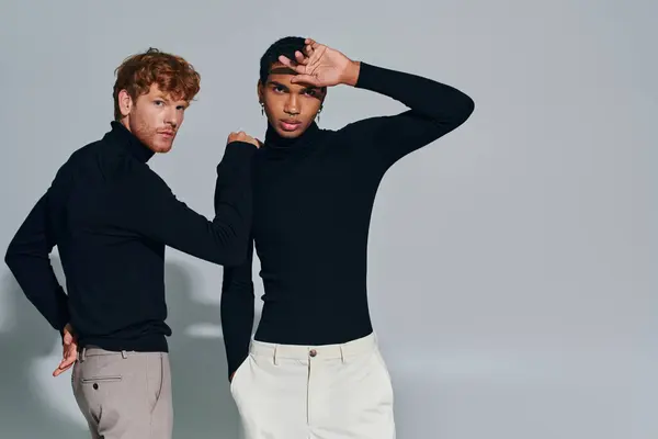 stock image red haired man with his hand on shoulder of african american man in black turtlenecks, fashion