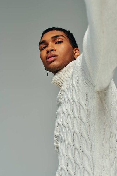 portrait of handsome young african american man in sweater with accessories looking at camera