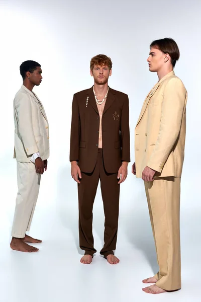 vertical shot of stylish men in vivid attires in profile and red haired man in unbuttoned suit