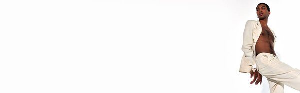 stylish african american man in elegant sexy suit with hands behind back, fashion concept, banner