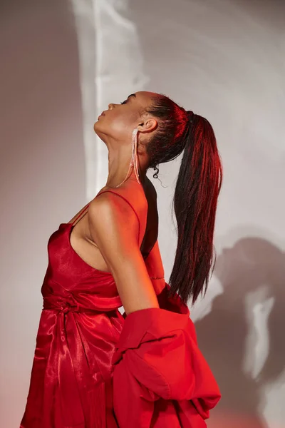 Kırmızı Ceketli Elbiseli Afro Amerikan Modeli Gri Aynalı Arka Planda — Stok fotoğraf