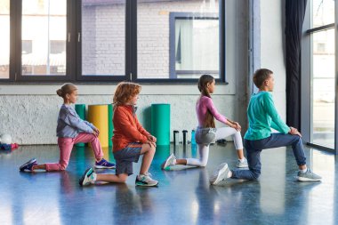 pretty little children in sportswear stretching in gym, looking in front of them, child sport clipart