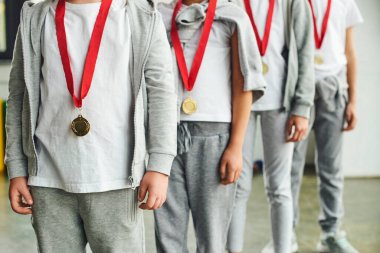 cropped view of four children in sportswear with golden medals on their necks, child sport clipart