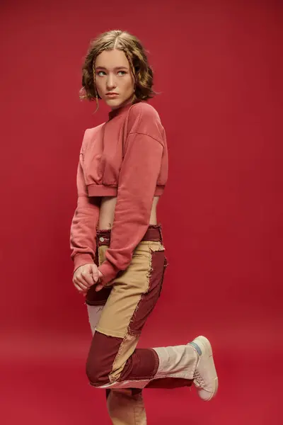 Gençlik Tarzı Yama Pantolonlu Utangaç Güzel Bir Kadın Kırmızı Arkaplanda — Stok fotoğraf