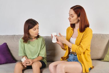 mother showing sanitary pads to teenage daughter during sex education at home, feminine care clipart