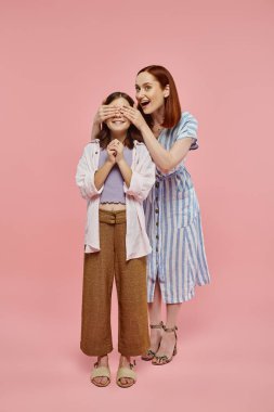 Genç kızın gözlerini kapayan neşeli ve şık bir kadın. Bil bakalım pembe ile kim oynuyor?