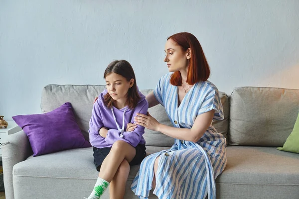 stock image caring mother calming upset teenage daughter sitting on couch in living room, care and support