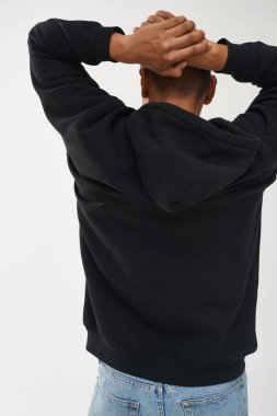 Gündelik siyah kapüşonlu ve kot pantolonlu modacı Afro-Amerikan erkek model, reklam için fotokopi alanı