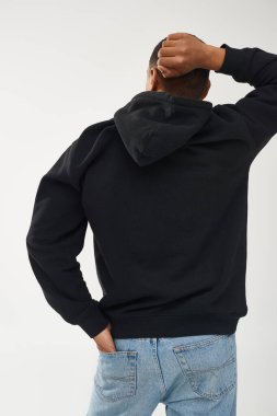 Gündelik siyah kapüşonlu ve kot pantolonlu modacı Afro-Amerikan erkek model, reklam için fotokopi alanı