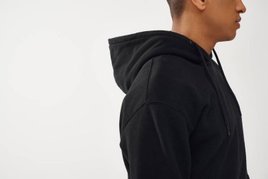 Siyah kapüşonlu Afro-Amerikan bir adamın beyaz arka planda görünümü, moda konsepti