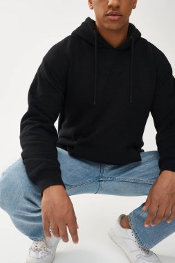 Gündelik siyah kapüşonlu ve kot pantolonlu modacı Afro-Amerikan erkek model, reklam için fotokopi alanı