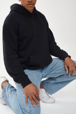 Gündelik siyah kapüşonlu ve kot pantolonlu modacı Afro-Amerikan erkek model, reklam için fotokopi alanı