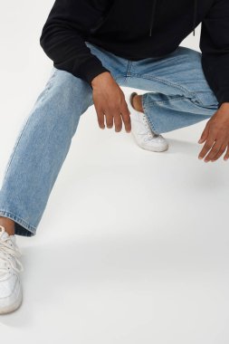 Gündelik siyah kapüşonlu ve kot pantolonlu modacı Afro-Amerikan erkek model, reklam için fotokopi alanı