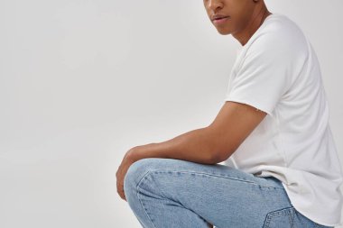 Havalı günlük kot pantolon ve beyaz tişört giyen şık Afro-Amerikan erkeği, reklam için kopya alanı