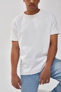 Havalı günlük kot pantolon ve beyaz tişört giyen şık Afro-Amerikan erkeği, reklam için kopya alanı
