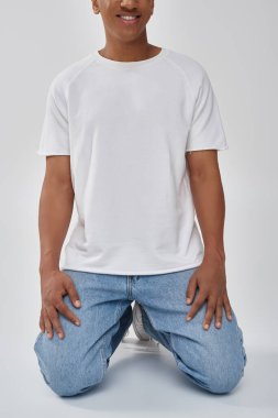 stylish african american man in trendy casual jeans and white t-shirt, copy space for advertising clipart