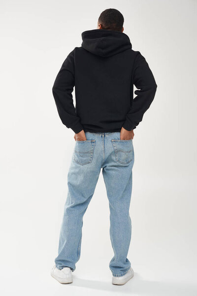 модный африканский мужчина-модель в повседневной черной толстовке и джинсах, копировальное место для рекламы