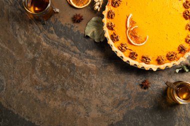 Sıcak çayın yanında cevizli ve portakal dilimli balkabağı turtası, sonbahar şükran günü natürmortu.