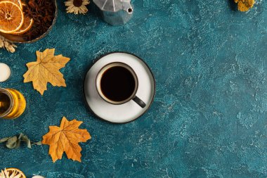 Baharatların yanında sonbahar yaprakları ve bir fincan koyu kahve ve mavi desenli yüzey üzerinde bal, şükran günü.