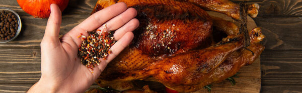 delicious thanksgiving dinner, cropped view of man holding spices near grilled turkey, banner