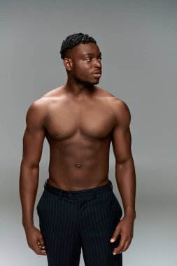Siyah pantolonlu, siyah bakışlı, kaslı Afrikalı Afrikalı Amerikalı adam.