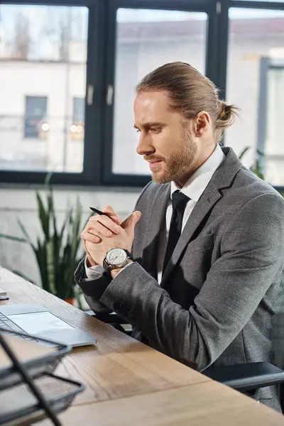 stock image thoughtful businessman sitting with folded hands near laptop on work desk in modern office