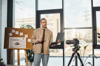 Bilgisayarlı bir işadamı modern ofiste analitik ve dijital kamerayla yakın plan hakkında konuşuyor.