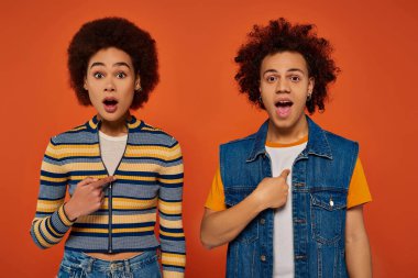 Şok olmuş genç Afro-Amerikan kardeşler günlük kıyafetler içinde şaşırmış görünüyorlar, aile kavramı.