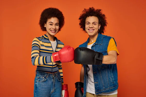 ジョリー アフリカ系アメリカ人の兄弟 ボクシング手袋で一緒に楽しんだ オレンジ色の背景 — ストック写真