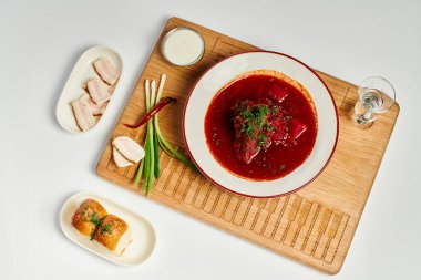 Sarımsaklı çörekler, domuz yağı ve ahşap kesim tahtasındaki ekşi krema yanında nefis Ukrayna çorbası.
