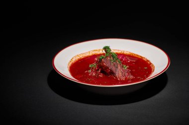 Doğu Avrupa mutfağı, geleneksel Ukrayna borsch 'u. Siyah arka planda seramik kasede sığır eti.