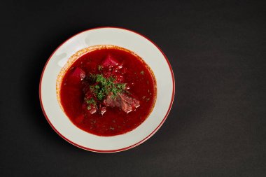Doğu Avrupa yemeği, geleneksel Ukrayna borsch 'u seramik kasede sığır eti ile siyah zemin üzerinde